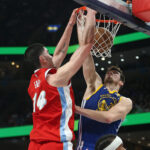 Apr 1, 2025; Memphis, Tennessee, USA; Memphis Grizzlies center Zach Edey (14) dunks over Golden State Warriors center Quinten Post (21) during the second quarter at FedExForum.