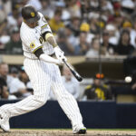 Jul 7, 2025; San Diego, California, USA; San Diego Padres third baseman Manny Machado (13) hits a single during the fourth inning against the Arizona Diamondbacks at Petco Park. The hit was his 2000th career hit. Mandatory Credit: Denis Poroy-Imagn Images