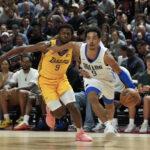 Jul 10, 2025; Las Vegas, NV, USA; Dallas Mavericks guard Ryan Nembhard (9) drives past Los Angeles Lakers guard Bronny James (9) in the first quarter of the game at Thomas & Mack Center.