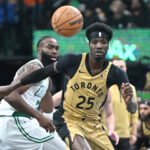 Nov 17, 2023; Toronto, Ontario, CAN; Toronto Raptors forward Chris Boucher (25) pursues a loose ball ahead of Boston Celtics guard Jaylen Brown (7) in the first half at Scotiabank Arena.
