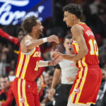Oct 23, 2024; Atlanta, Georgia, USA; Atlanta Hawks forward Zaccharie Risacher (10) reacts with guard Trae Young (11) after making a three point basket for his first points in the NBA against the Brooklyn Nets during the first half at State Farm Arena.