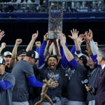 MLB playoffs Oct 31, 2024; New York, New York, USA; Los Angeles Dodgers shortstop Mookie Betts (50) celebrates with the Commissioner’s Trophy after the Los Angeles Dodgers beat the New York Yankees in game four to win the 2024 MLB World Series at Yankee Stadium. Mandatory Credit: Brad Penner-Imagn Images