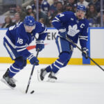 Mar 19, 2025; Toronto, Ontario, CAN; Toronto Maple Leafs forward Mitch Marner (16) gets control of the puck as forward Auston Matthews (34) trails the play against the Colorado Avalanche during the third period at Scotiabank Arena. Mandatory Credit: John E. Sokolowski-Imagn Images
