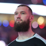 Apr 6, 2025; Portland, Oregon, USA; San Antonio Spurs power forward Sandro Mamukelashvili (54) stands for the National Anthem before the game against the Portland Trail Blazers at Moda Center. Mandatory Credit: Soobum Im-Imagn Images