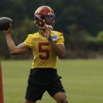 Jul 23, 2025; Ashburn, VA, USA; Washington Commanders quarterback Jayden Daniels (5) passes a ball during practice on day one of training camp at OrthoVirginia Training Center at Commanders Park. Mandatory Credit: Geoff Burke-Imagn Images