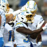 Jul 31, 2025; Canton, Ohio, USA; Los Angeles Chargers running back Kimani Vidal (30) celebrates with teammates after scoring a touchdown against the Detroit Lions in the first quarter at Tom Benson Hall of Fame Stadium.