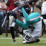 Aug 10, 2025; Chicago, Illinois, USA; Miami Dolphins running back Alexander Mattison (8) runs the ball and is tackled by Chicago Bears defensive back Alex Cook (30) tackles him during the second half at Soldier Field. Mandatory Credit: David Banks-Imagn Images