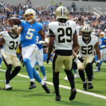 Aug 10, 2025; Inglewood, California, USA; Los Angeles Chargers quarterback Trey Lance (5) scores on a 5-yard touchdown run against New Orleans Saints safety Jordan Howden (31), cornerback Quincy Riley (29) and linebacker D'Marco Jackson (52) in the first half at SoFi Stadium. Mandatory