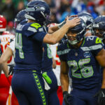 Aug 15, 2025; Seattle, Washington, USA; Seattle Seahawks running back Zach Charbonnet (26) celebrates with quarterback Sam Darnold (14) after rushing for a touchdown against the Kansas City Chiefs during the first quarter at Lumen Field. Mandatory Credit: Joe Nicholson-Imagn Images