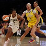Resultados WNBA 29/08 Aug 29, 2025; Los Angeles, California, USA; Indiana Fever guard Kelsey Mitchell (0) drives to the basket past Los Angeles Sparks forward Dearica Hamby (5) during the first quarter at Crypto.com Arena. Mandatory Credit: Kiyoshi Mio-Imagn Images