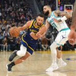 Feb 23, 2024; San Francisco, California, USA; Golden State Warriors guard Stephen Curry (left) dribbles against Charlotte Hornets forward Cody Martin (11) during the first quarter at Chase Center.