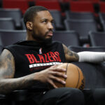 Mar 27, 2023; Portland, Oregon, USA; Portland Trail Blazers point guard Damian Lillard (0) watches players warm up prior to the game against the New Orleans Pelicans at Moda Center. Mandatory Credit: Soobum Im-USA TODAY Sports