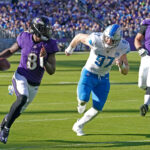 Oct 22, 2023; Baltimore, Maryland, USA; NFL; Baltimore Ravens quarterback Lamar Jackson (8) is pressured by Detroit Lions defensive lineman Aidan Hutchinson (97) during the fourth quarter at M&T Bank Stadium.