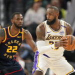 Jan 25, 2025; San Francisco, California, USA; Los Angeles Lakers forward LeBron James (right) handles the ball against Golden State Warriors forward Andrew Wiggins (22) during the third quarter at Chase Center. Mandatory Credit: Darren Yamashita-Imagn Images