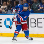 Mar 22, 2025; New York, New York, USA; New York Rangers center J.T. Miller (8) clears the puck against the Vancouver Canucks during the second period at Madison Square Garden. Mandatory Credit: Danny Wild-Imagn Images