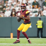 Sep 11, 2025; Green Bay, Wisconsin, USA; Washington Commanders quarterback Jayden Daniels (5) looks to pass against the Green Bay Packers in the second quarter at Lambeau Field. Mandatory Credit: Jeff Hanisch-Imagn Images