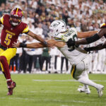 Sep 11, 2025; Green Bay, Wisconsin, USA; Washington Commanders quarterback Jayden Daniels (5) scrambles away from Green Bay Packers defensive end Lukas Van Ness (90) at Lambeau Field. Mandatory Credit: Tork Mason-USA TODAY Network via Imagn Images