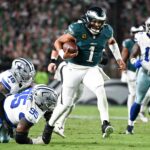Sep 4, 2025; Philadelphia, Pennsylvania, USA; Philadelphia Eagles quarterback Jalen Hurts (1) avoids a tackle by Dallas Cowboys defensive tackle Kenny Clark (95) during the second quarter of the game at Lincoln Financial Field.
