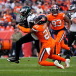 Nov 14, 2021; Denver, Colorado, USA; NFL; Denver Broncos cornerback Ronald Darby (21) tackles Philadelphia Eagles wide receiver DeVonta Smith (6) in the second quarter at Empower Field at Mile High.
