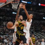 Mar 31, 2024; San Antonio, Texas, USA; Golden State Warriors guard Stephen Curry (30) looks to pass under the arm of San Antonio Spurs center Victor Wembanyama (1) in the first half at Frost Bank Center.