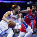 Nov 12, 2024; Philadelphia, Pennsylvania, USA; New York Knicks guard Jalen Brunson (11) drives in front of Philadelphia 76ers forward Paul George (8) during the second quarter at Wells Fargo Center.