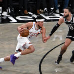 Jan 22, 2025; Brooklyn, New York, USA; Phoenix Suns guard Devin Booker (1) drives to the basket while being defended by Brooklyn Nets guard Tyrese Martin (13) during the second half at Barclays Center.