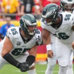 Sep 14, 2025; Kansas City, Missouri, USA; Philadelphia Eagles offensive tackle Lane Johnson (65) talks with guard Tyler Steen (56) on the line of scrimmage against the Kansas City Chiefs during the game at GEHA Field at Arrowhead Stadium. Mandatory Credit: Denny Medley-Imagn Images