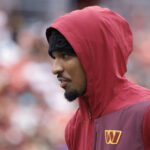Sep 21, 2025; Landover, Maryland, USA; Injured Washington Commanders quarterback Jayden Daniels walks off the field after the Commanders' game against the Las Vegas Raiders at Northwest Stadium. Mandatory Credit: Amber Searls-Imagn Images