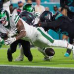 Sep 29, 2025; Miami Gardens, Florida, USA; New York Jets running back Braelon Allen (0) fumbles the ball against Miami Dolphins defensive back Elijah Campbell (22) during the first half at Hard Rock Stadium. Mandatory Credit: Sam Navarro-Imagn Images
