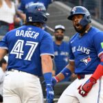 Oct 4, 2025; Toronto, Ontario, CAN; Toronto Blue Jays first baseman Vladimir Guerrero Jr. (27) celebrates with third baseman Addison Barger (47) after hitting a home run in the first inning against the New York Yankees during game one of the ALDS round for the 2025 MLB playoffs at Rogers Centre.