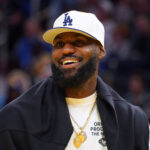 LeBron Lakers Oct 5, 2025; San Francisco, California, USA; Los Angeles Lakers forward LeBron James (23), wearing a Los Angeles Dodgers hat, watches from the sideline during a break against the Golden State Warriors in the third quarter at Chase Center.