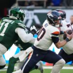 Oct 12, 2025; Tottenham, United Kingdom; Denver Broncos quarterback Bo Nix (10) is pressured by New York Jets linebacker Jermaine Johnson II (11) during an NFL International Series game at Tottenham Hotspur Stadium. Mandatory Credit: Kirby Lee-Imagn Images