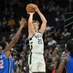Oct 14, 2025; Milwaukee, Wisconsin, USA; Milwaukee Bucks guard AJ Green (20) hits a three point shot against the Oklahoma City Thunder during the first half at Fiserv Forum. Mandatory Credit: Patrick Gorski-Imagn Images
