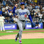 Oct 14, 2025; Milwaukee, Wisconsin, USA; Los Angeles Dodgers pitcher Yoshinobu Yamamoto (18) throws to first base to get out Milwaukee Brewers designated hitter Christian Yelich (not pictured) in the ninth inning during game two of the NLCS round for the 2025 MLB playoffs at American Family Field. Mandatory Credit: Benny Sieu-Imagn Images