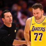 Oct 14, 2025; Phoenix, Arizona, USA; Los Angeles Lakers guard Luka Doncic (77) with head coach JJ Redick against the Phoenix Suns during an NBA preseason game at Mortgage Matchup Center.
