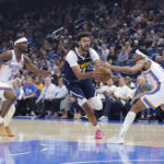 Oct 17, 2025; Oklahoma City, Oklahoma, USA; Denver Nuggets forward Cameron Johnson (23) drives between Oklahoma City Thunder guard Shai Gilgeous-Alexander (2) and guard Aaron Wiggins (21) during the first half at Paycom Center. Mandatory Credit: Alonzo Adams-Imagn Images