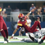 Oct 19, 2025; Arlington, Texas, USA; Washington Commanders quarterback Jayden Daniels (5) fumbles the ball defended by Dallas Cowboys linebacker Shemar James (50) during the third quarter of the game at AT&T Stadium. Mandatory Credit: Kevin Jairaj-Imagn Images