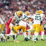 Playoffs da NFL Oct 19, 2025; Glendale, Arizona, USA; Green Bay Packers quarterback Jordan Love (10) hands off to Green Bay Packers running back Emanuel Wilson (23) during the second half against the Arizona Cardinals at State Farm Stadium. Mandatory Credit: Joe Camporeale-Imagn Images