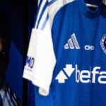 Camisa do Cruzeiro com pôster do Lucas Romero ao fundo