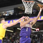 Oct 3, 2025; Palm Desert, California, USA; Phoenix Suns guard Devin Booker (1) shoots past Los Angeles Lakers guard Dalton Knecht (4) at Acrisure Arena.