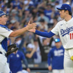 Oct 16, 2025; Los Angeles, California, USA; Los Angeles Dodgers catcher Will Smith (16) and pitcher Roki Sasaki (11) celebrate after defeating the Milwaukee Brewers in game three of the NLCS round for the 2025 MLB playoffs at Dodger Stadium.