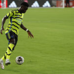 Saka em campo pelo Arsenal, de uniforme verde-limão do Arsenal