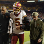 Nov 2, 2025; Landover, Maryland, USA; Washington Commanders quarterback Jayden Daniels (5) is helped off the field after an injury during the second half against the Seattle Seahawks at Northwest Stadium. Mandatory Credit: Amber Searls-Imagn Images