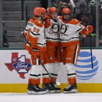 Nov 6, 2025; Dallas, Texas, USA; Anaheim Ducks defenseman Pavel Mintyukov (98) and defenseman Ian Moore (74) and center Ryan Poehling (25) celebrates a goal scored by Moore against the Dallas Stars during the second period at the American Airlines Center. Mandatory Credit: Jerome Miron-Imagn Images