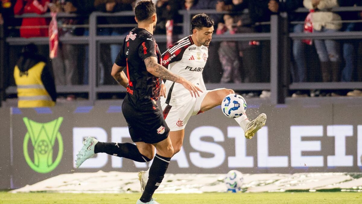 Meia Arrascaeta (camisa branca) com a bola e o zagueiro Pedro Henrique (camisa preta) marcando em Flamengo x Bragantino do 1º turno do Brasileirão 2025, em Bragança Paulista