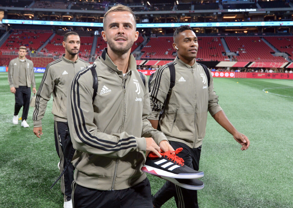 Pjanic, ex-Juventus e Barcelona, caminhando em estádio palco de jogo das estrelas com o abrigo da Juventus em 2018 - Alex Sandro, do Flamengo, aparece ao seu lado, na direita