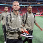 Pjanic, ex-Juventus e Barcelona, caminhando em estádio palco de jogo das estrelas com o abrigo da Juventus em 2018 - Alex Sandro, do Flamengo, aparece ao seu lado, na direita