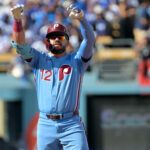 Oct 9, 2025; Los Angeles, California, USA; Philadelphia Phillies left fielder Kyle Schwarber (12) reacts after a double in the first inning against the Los Angeles Dodgers during game four of the NLDS round for the 2025 MLB playoffs at Dodger Stadium. Mandatory Credit: Jayne Kamin-Oncea-Imagn Images