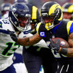 Semana 16 da NFL Nov 16, 2025; Inglewood, California, USA; Los Angeles Rams running back Kyren Williams (23) against Seattle Seahawks linebacker Ernest Jones IV (13) during the second half at SoFi Stadium. Mandatory Credit: Gary A. Vasquez-Imagn Images