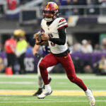 Dec 7, 2025; Minneapolis, Minnesota, USA; Washington Commanders quarterback Jayden Daniels (5) rushes the ball against the Minnesota Vikings during the first half at U.S. Bank Stadium. Mandatory Credit: Jeffrey Becker-Imagn Images